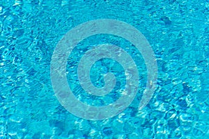 Blue water in swimming pool background. Ripple Water in swimming pool with sun reflection. Blue swimming pool rippled water detail