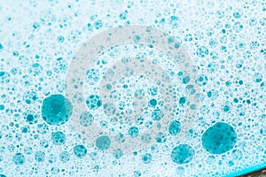 Blue water with white foam bubbles. Foam Water Soap Suds.Texture Foam Close-up. blue soap bubbles .Laundry and cleaning