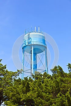 Blue watertower against a blue cloudy sky photo
