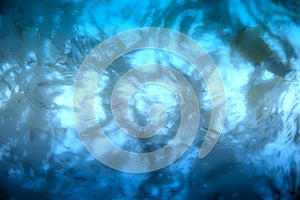 Blue wave abstract or rippled water on the surface. Water waves with shining and bubbles texture background.
