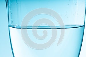 blue wave of water in a glass vessel. clean clear water