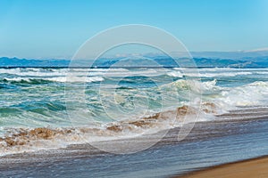 Blue waves breaking on the shore, California coastline