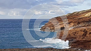 Blue Waves of the Pacific Ocean Beats Oahu Island Volcanic Cliffs. Clear sunny day. Archipelago Hawaii. DCI 4k