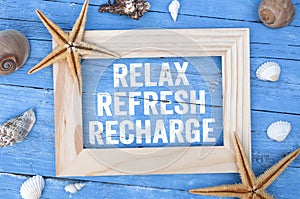 Blue weathered wood with marine or maritime decoration and message Reflex Refresh Recharge in a frame