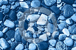 Blue wet pebble stones and water at morning seaside