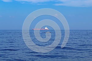 Blue whale's backs emerging from the water and a huge cargo ship, Sri Lanka