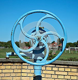 Blue wheel on water well pump, close up