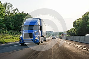 Blue 18 wheeler semi-truck on highway with motion blur