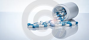 Blue-white antibiotic capsule pills spread out of plastic drug bottles. Antibiotic drug resistance. Prescription drugs. Healthcare