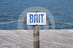 Blue and white bait sign in front of a boardwalk on the water