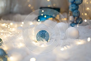 Blue and white baubles. Christmas tree toys and New Year decorations. Unfocused white background with shiny sparkling garland