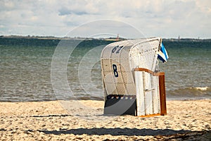 A blue and white beach chair is standing at the beach