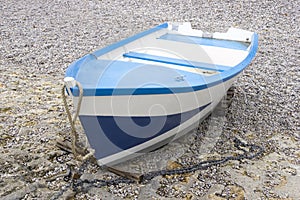 Blue and white boat on the shingle beach