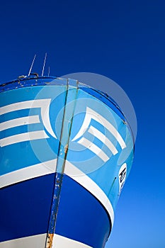 Blue and white bow of a trawler on a blue sky