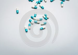 Blue-white capsule pills spread on white background. Pharmaceutical products. Global healthcare concept. Antibiotic drug