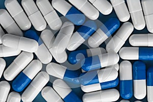 Blue and white capsules close up. Medicine pills capsules background.