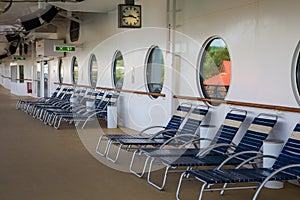 Blue and White Chaise Lounges Under Portholes