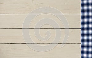 Blue and white checked table cloth on a white wood table