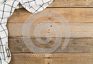 Blue and white checkered dishcloth on brown rustic wooden plank table flat lay top view from above