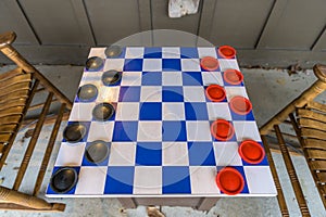 A blue and white checkers board with black and red game pieces, set up and ready for action, Lancaster County