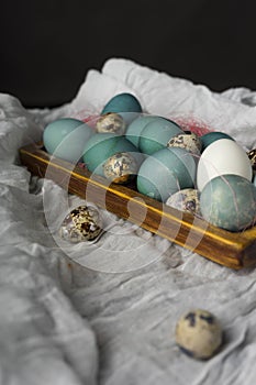 Blue, and white and chicken eggs and quail eggs in wooden retro