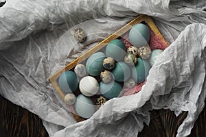 Blue, and white and chicken eggs and quail eggs in wooden retro