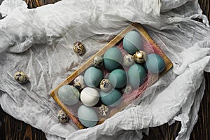 Blue, and white and chicken eggs and quail eggs in wooden retro