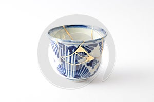Blue and white decorated cup repaired with the antique kintsugi real gold technique photo