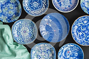 Blue and white decorative Japanese plates on black background -