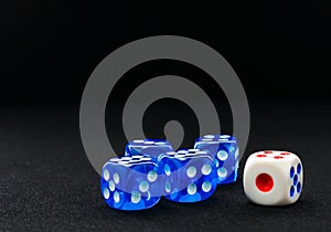 Blue and white dices on the black velvet surface