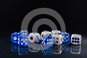 Blue and white dices on the glossy black background