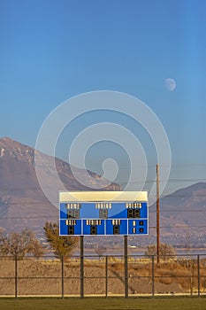 Blue and white electronic baseball scoreboard at a sports field