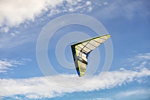 Blue and white hang glider in flight off with blue sky