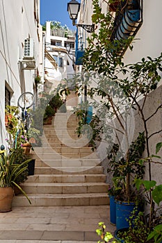 Blue and white houses in typical street in Barrio Santa Cruz in Alicante, Costa Blanca, Spain