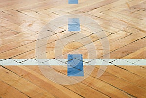 Blue white lines. Worn out wooden floor of sports hall with colorful marking lines.