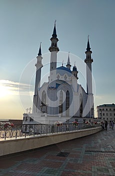 blue and white mosque in summer at sunset