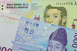 A blue and white one thousand won bill from Korea paired with a colorful five peso note from Argentina.