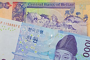 A blue and white one thousand won bill from Korea paired with a colorful two dollar bill from Belize.