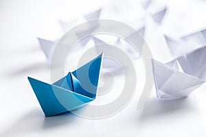 Blue and white paper boats. Concept of leadership boats for teamwork group or success