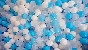 Blue and white plastic balls in ball pool at kids playground. Colorful plastic ball texture background. Many small colorful hollow