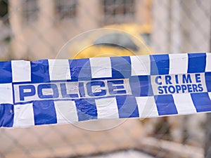 Blue and white Police tape cordoning off a crime scene area with a yellow car at a industrial area, Australia 2016 photo