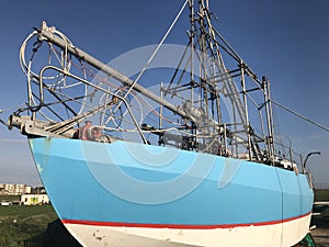 Blue, white and red boat, moored on land at New Brighton, Wirral