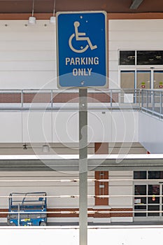 A blue and white reserved parking sign mounted on a metal pole