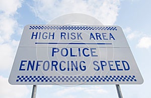 Blue and white road safety sign against a blue cloudy sky