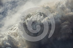 Blue and white sky puffy cumulonimbus clouds and smoke from a large wildfire