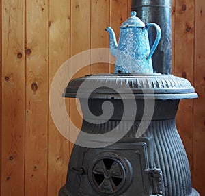 Blue And White Speckled Coffee Pot On Potbellied Stove photo