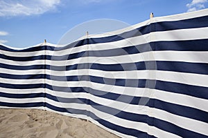 Blue and white striped windbreak at the beach photo