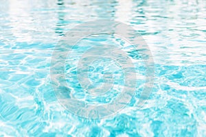 Blue white swimming pool ripped water surface with waves and nice sun sparkles