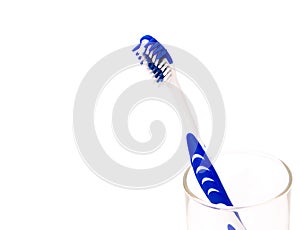 A blue white tooth brush in glass