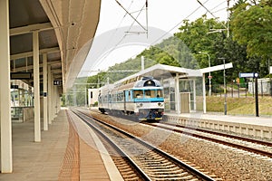 Train at the railway station. Blue train on the platform of the station.